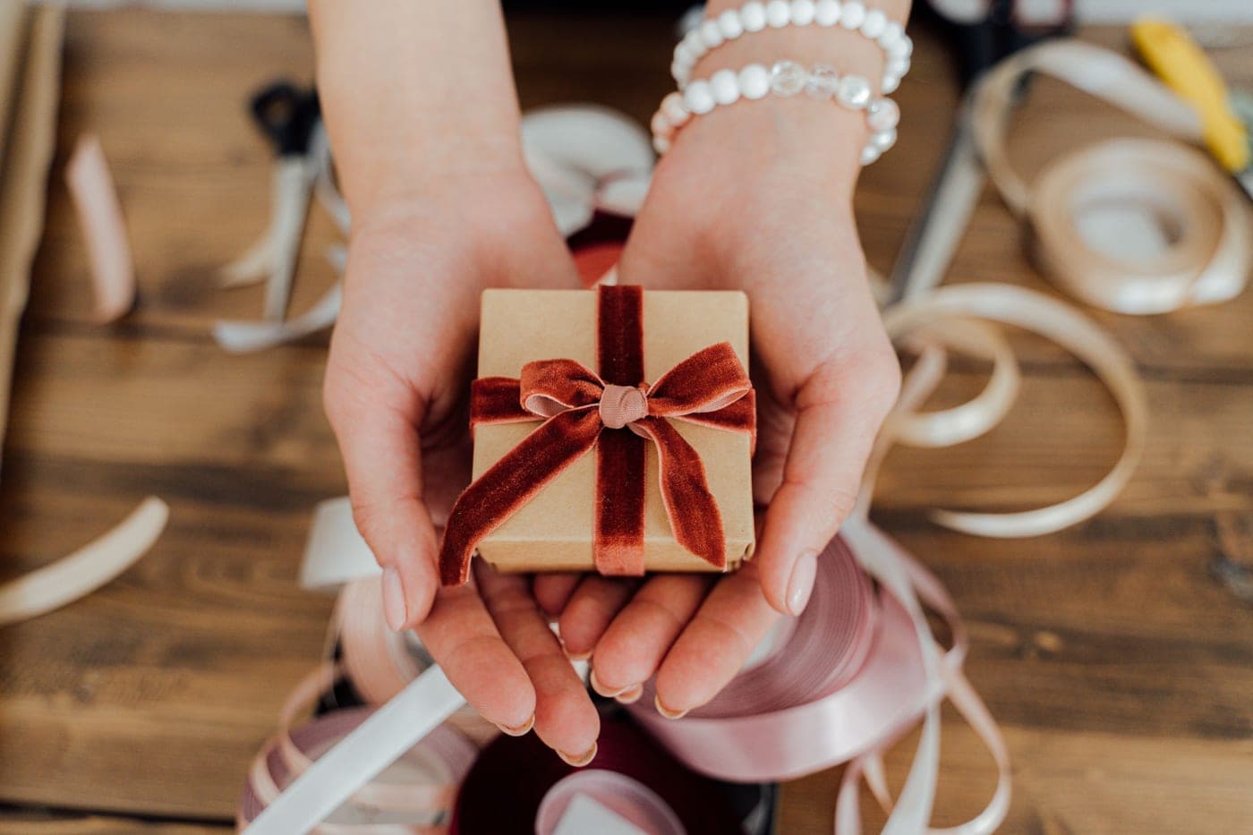 A small gift box tied with ribbon on a plain table