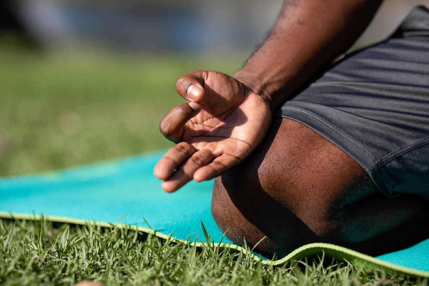 Close-up of hands resting on a mat during a kneeling pose