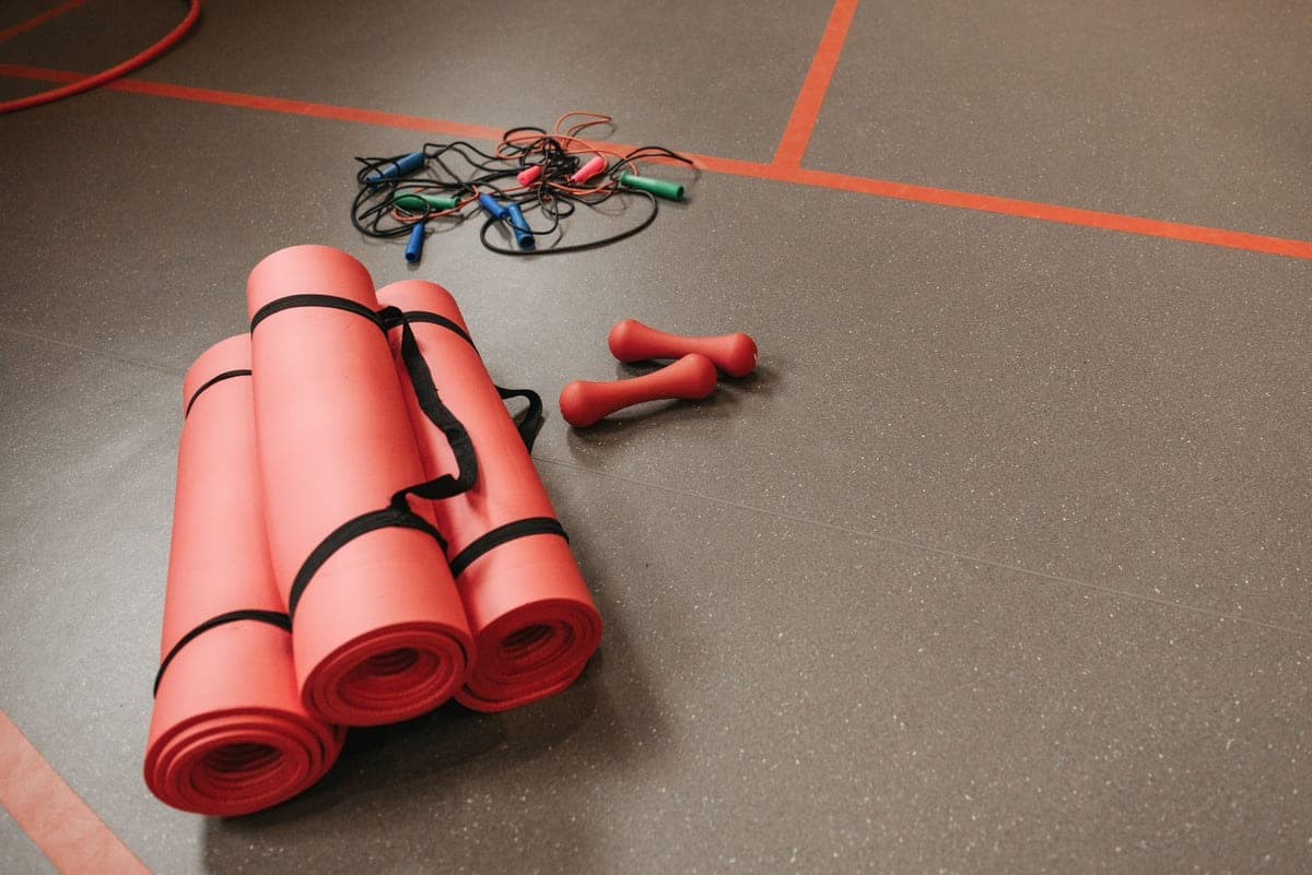 Stock photo: exercise mats, jump ropes and small weights arranged on a gym floor