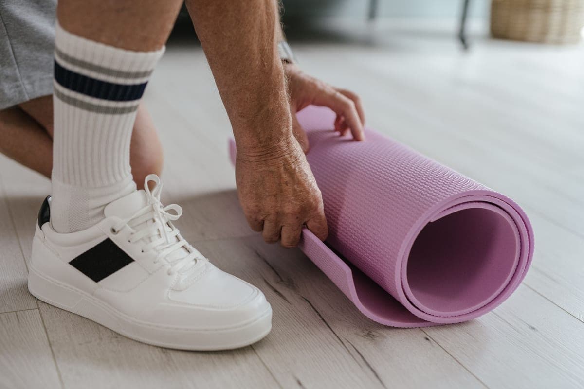 Stock photo: close-up of someone rolling a mat on a light wooden floor