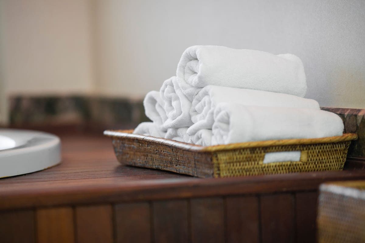Stock photo: rolled white towels stacked in a woven basket