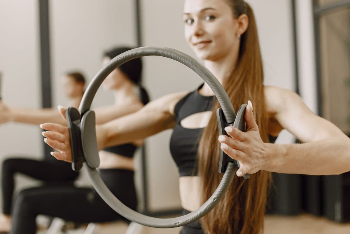 Stock photo: a pilates ring squeezed between the hands during a studio class