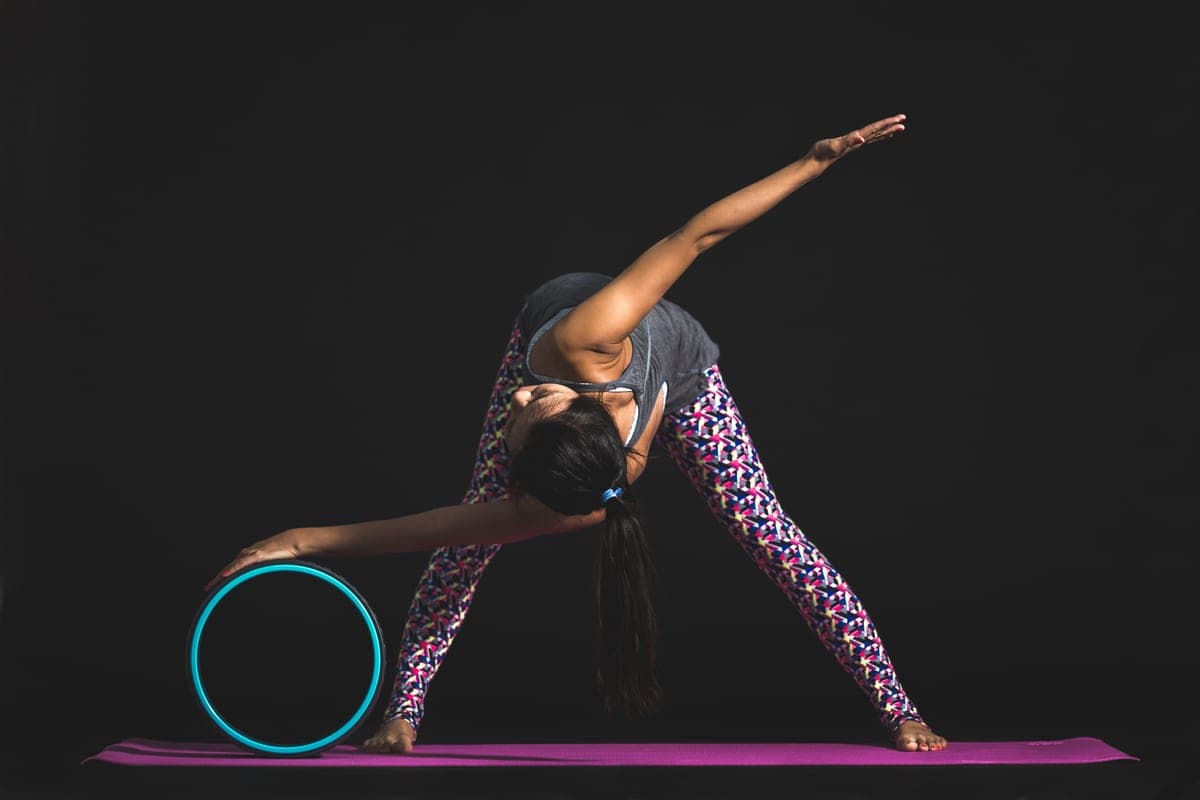 Stock photo: someone stretching back over a yoga wheel in a studio